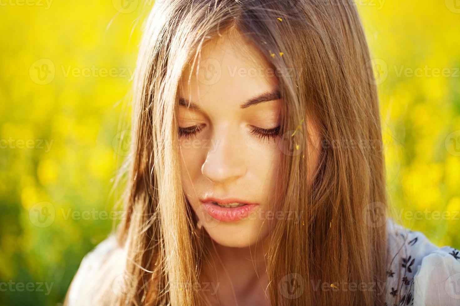 hermosa chica con cabello largo en flores amarillas foto