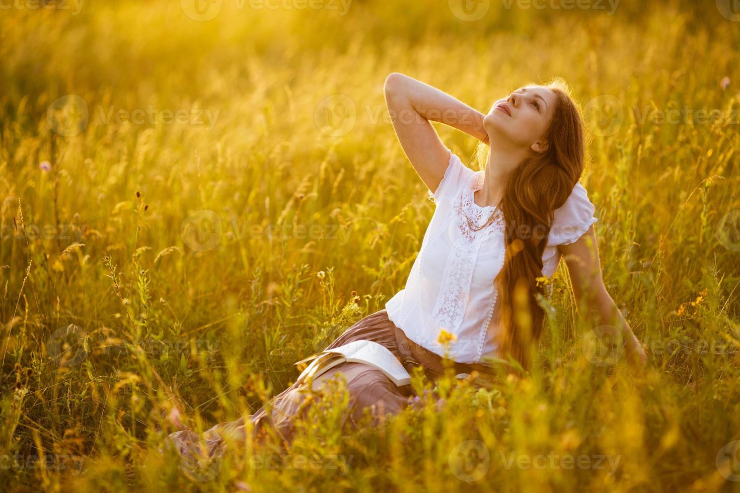 Happy girl with a book dreaming about something photo