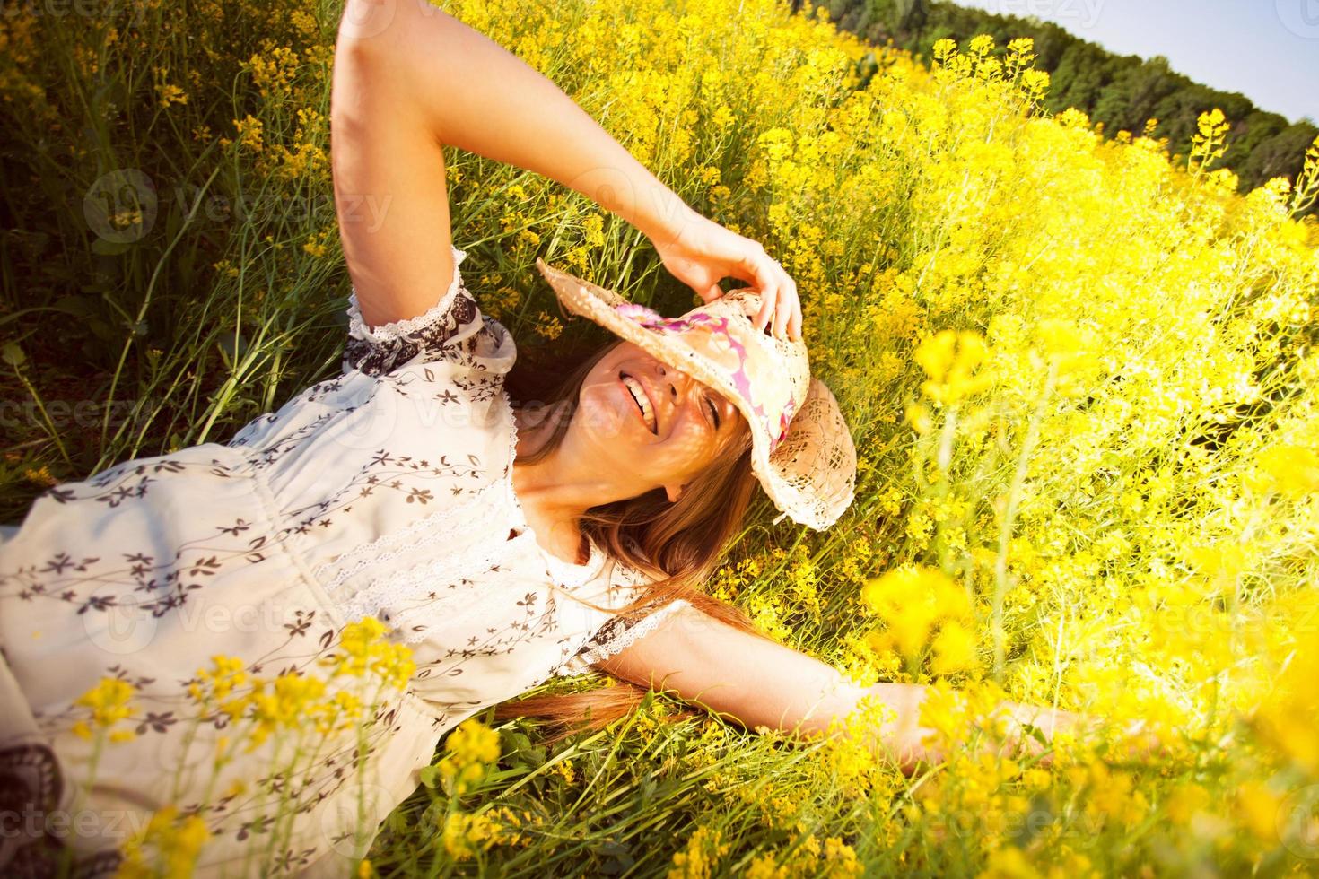 mujer feliz, acostado, entre, amarillo, flores silvestres foto