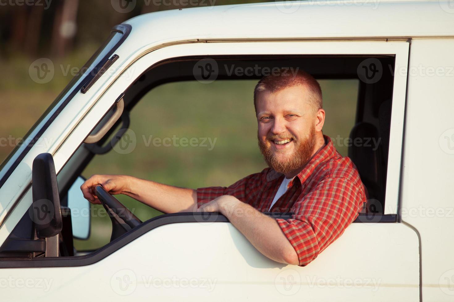 Smiling driver behind the wheel of car photo