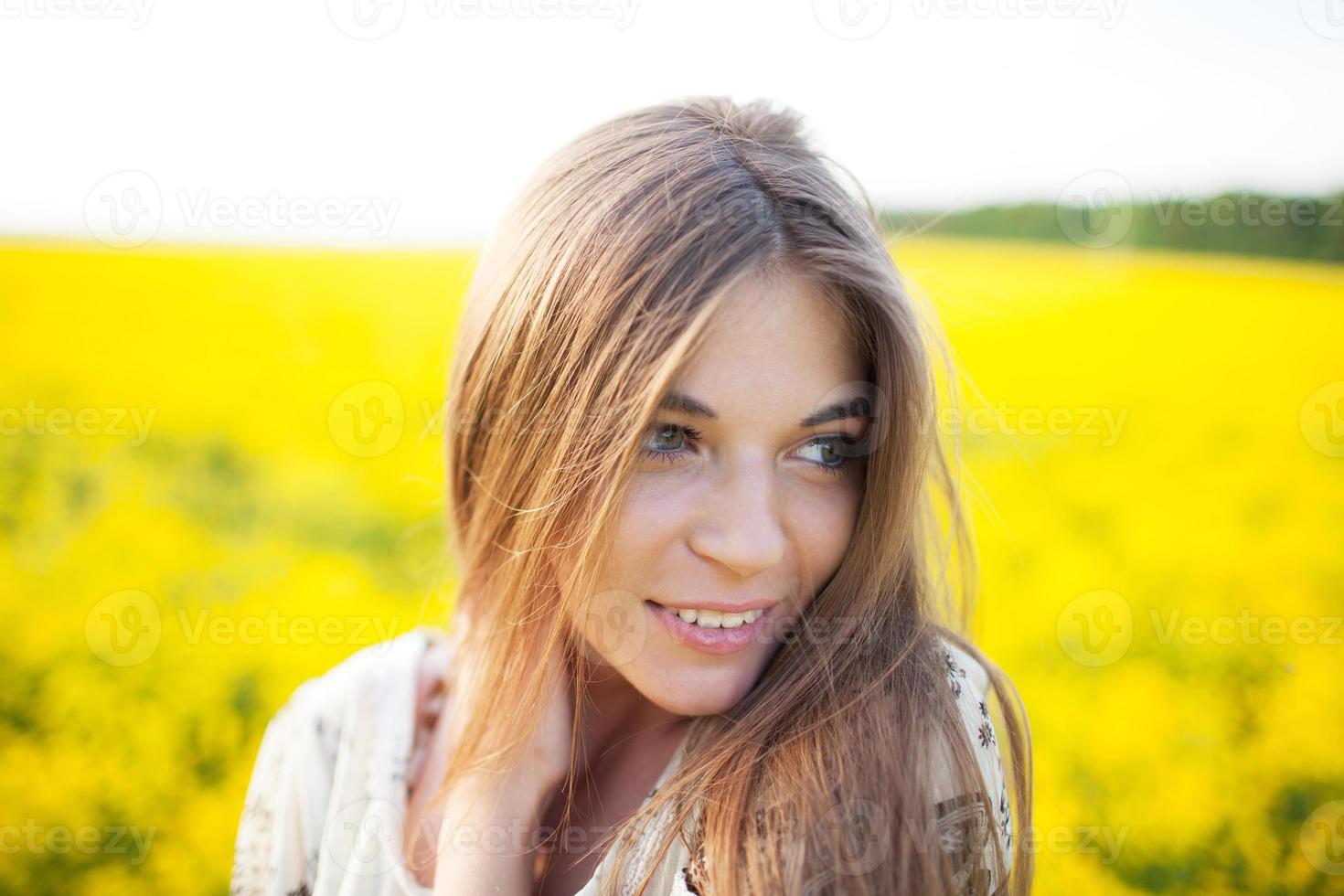 hermosa niña en un campo de flores amarillas foto