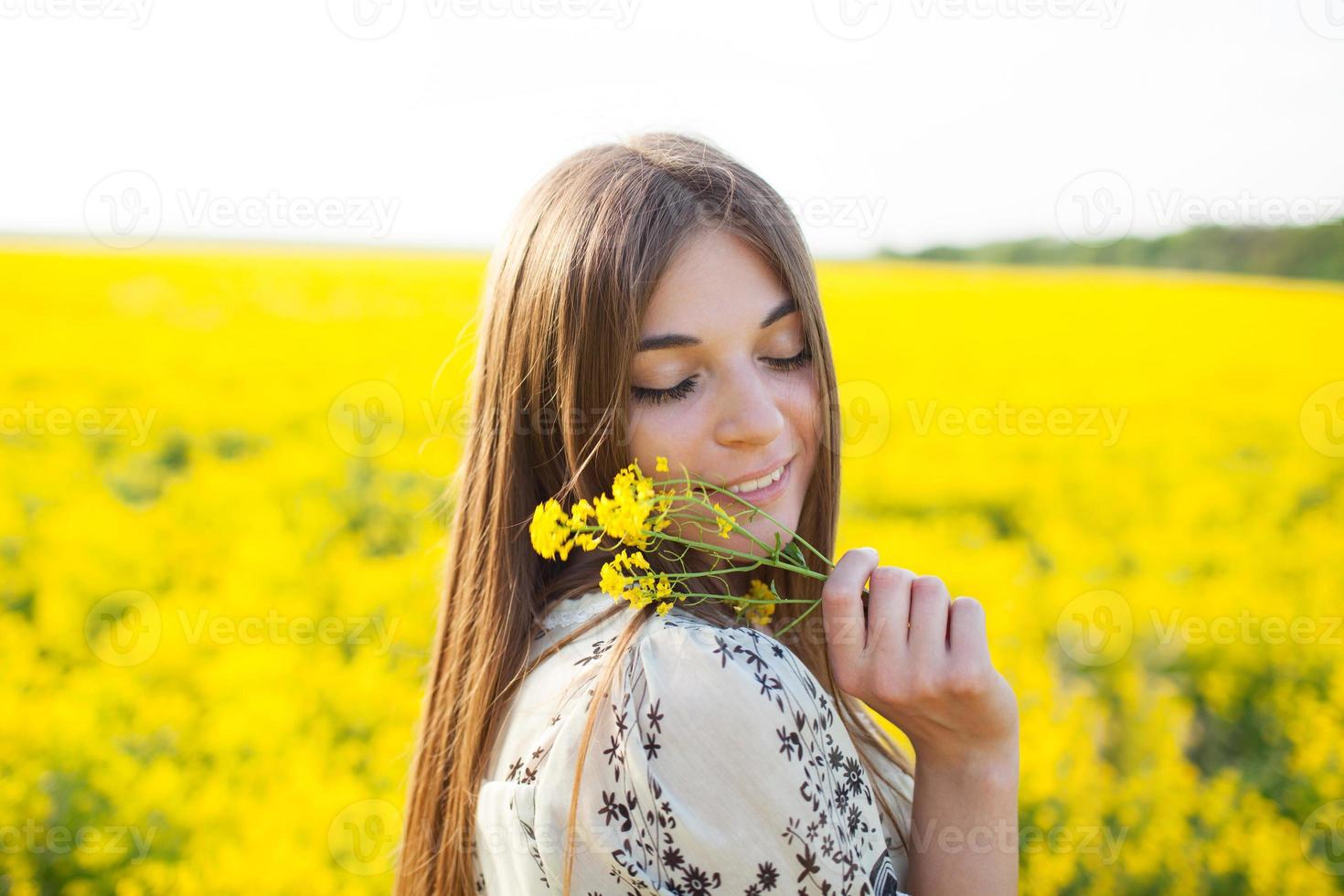 niña disfrutando del olor de las flores silvestres foto