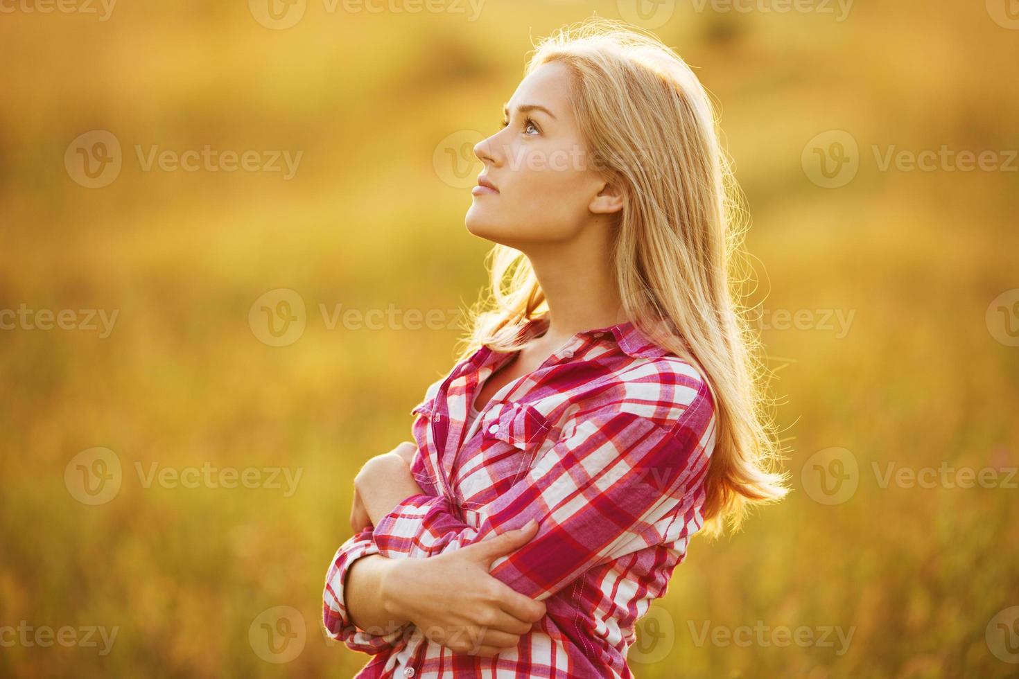 Beautiful blond girl in shirt looking up photo