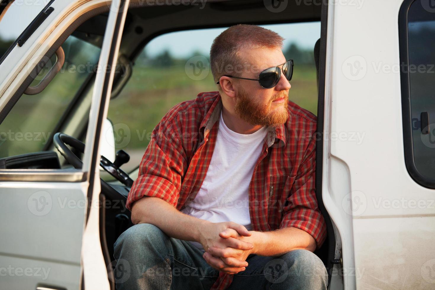 el conductor se sienta en la cabina de su camión foto