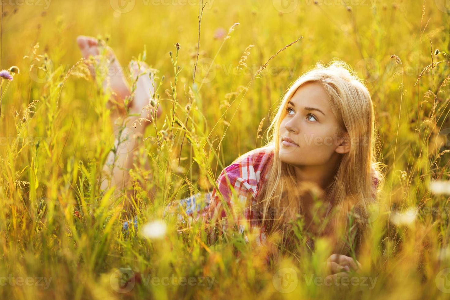 Beautiful blonde girl lying in the grass photo