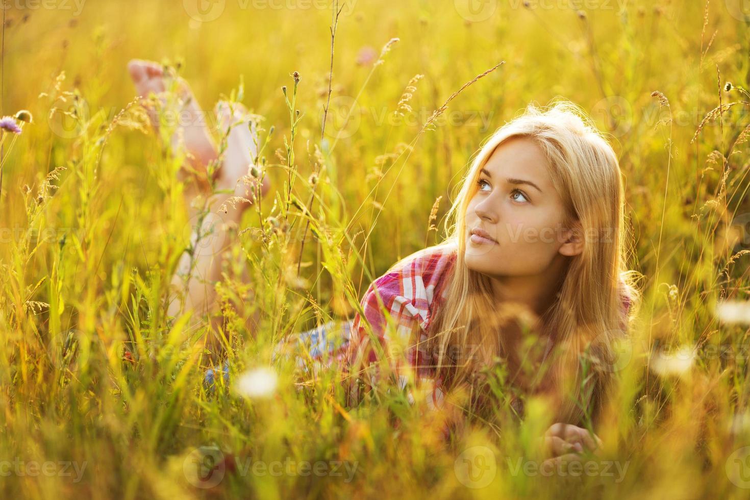 Beautiful blonde girl lying in the grass photo