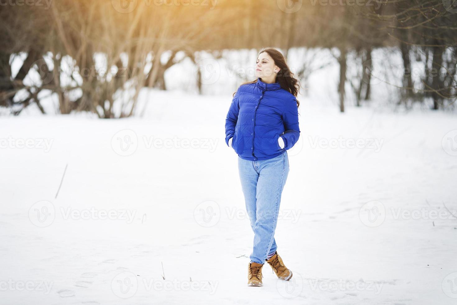 Girl in a jacket and jeans walks photo