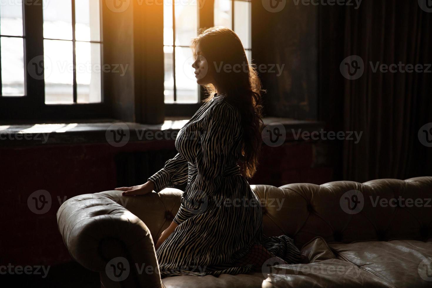 Girl sitting on the couch in the sun photo