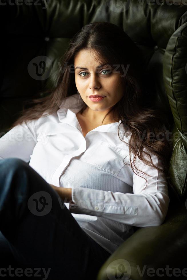 Girl sitting in a chair and looking at the camera photo