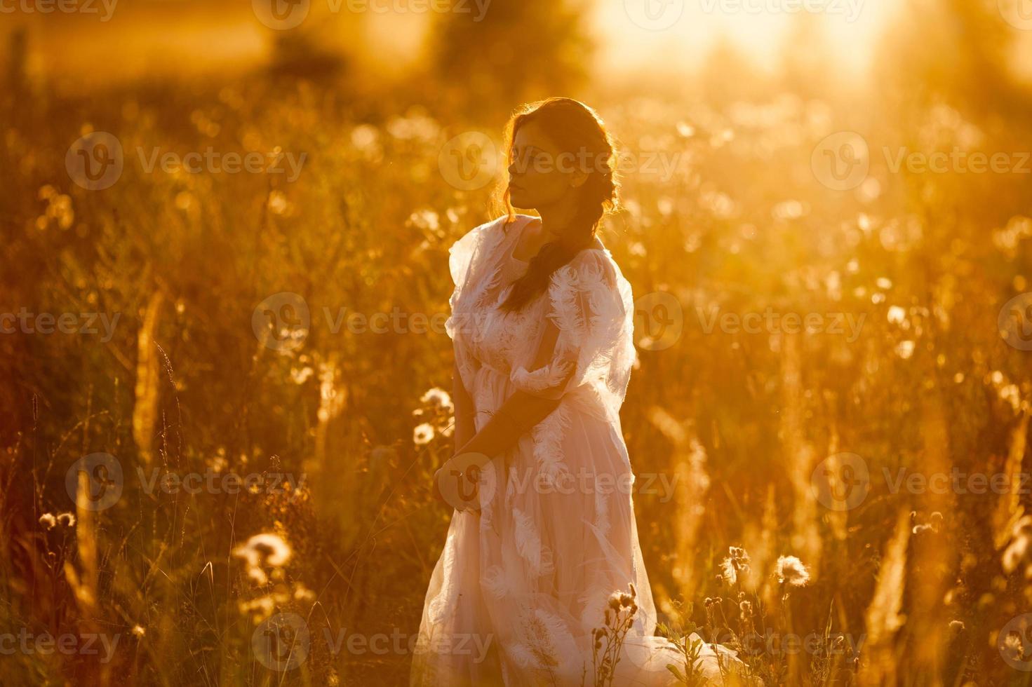 mujer caminando en el prado al atardecer foto