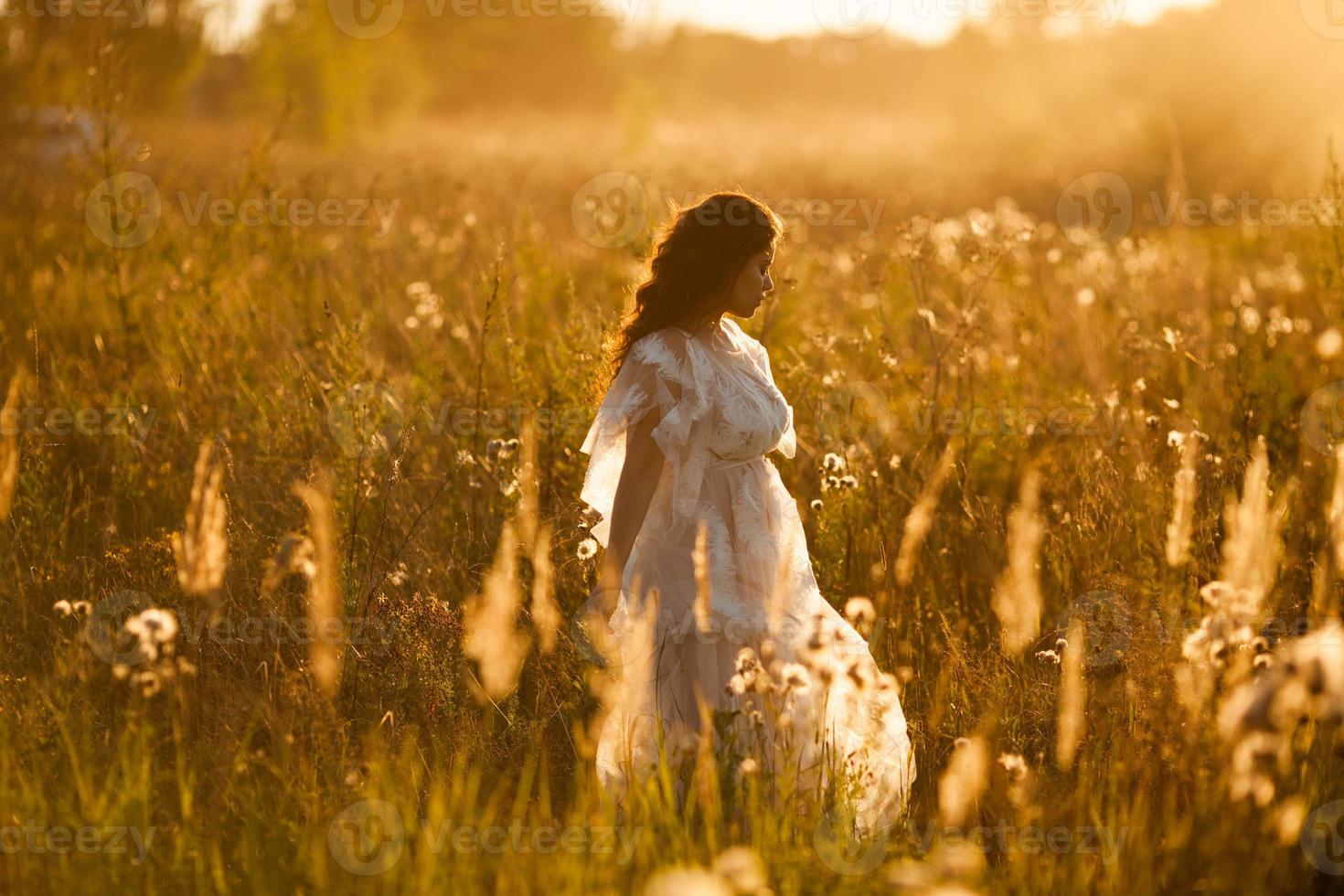 Girl walks through the meadow photo