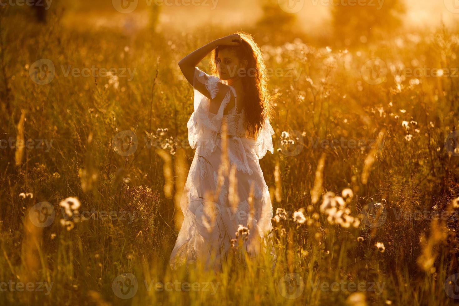 mujer de pie en el campo al atardecer foto