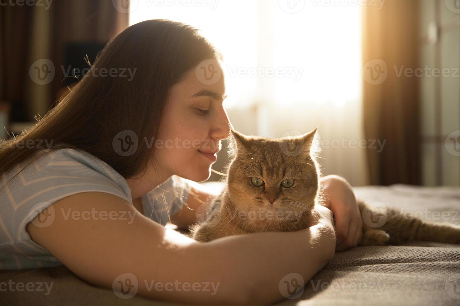 niña abrazando a su amado gato rojo. centrarse en el gato foto