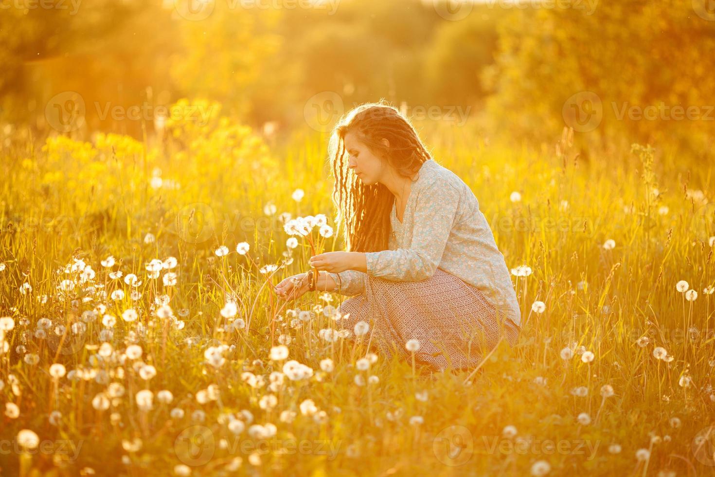 Girl among dandelions photo
