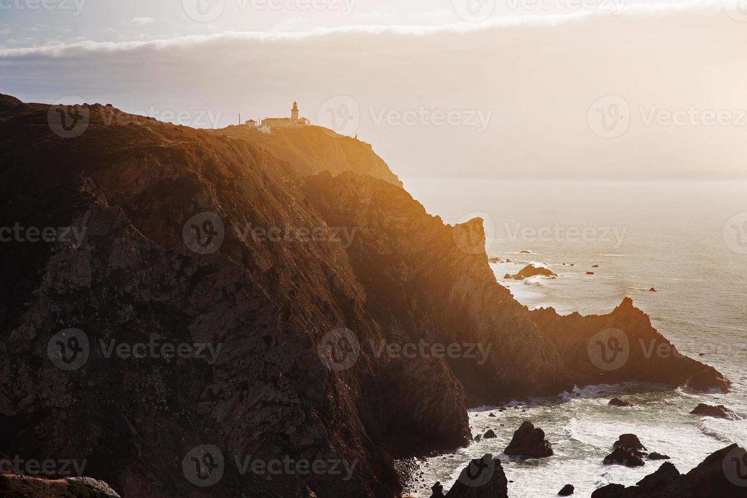 paisaje con un faro de pie en una montaña foto