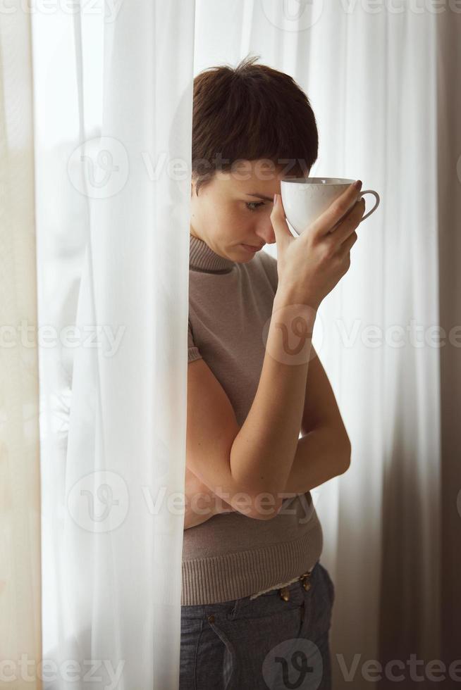 mujer triste con una taza de café foto