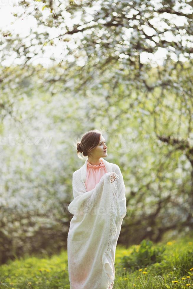 mujer feliz se encuentra en medio de un jardín floreciente foto