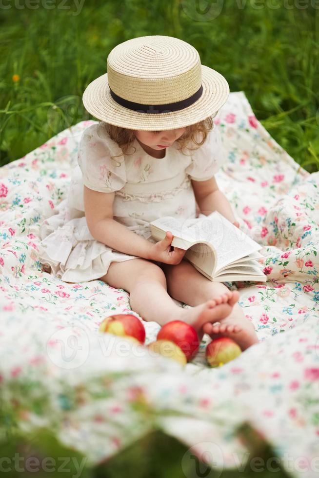 niña sentada y leyendo un libro foto