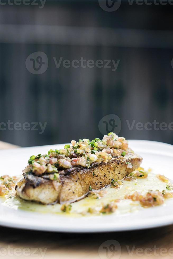 Fresh sea fish fillet with spicy salsa vegetable sauce photo