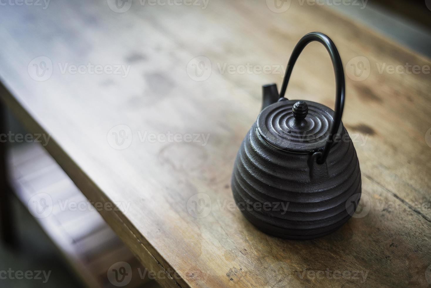 Tetera tradicional japonesa antigua sobre mesa de madera rústica foto