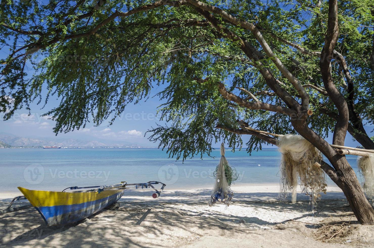 Fishing boats and nets on Areia Bbranca tropical beach in Dili east Timor Leste photo