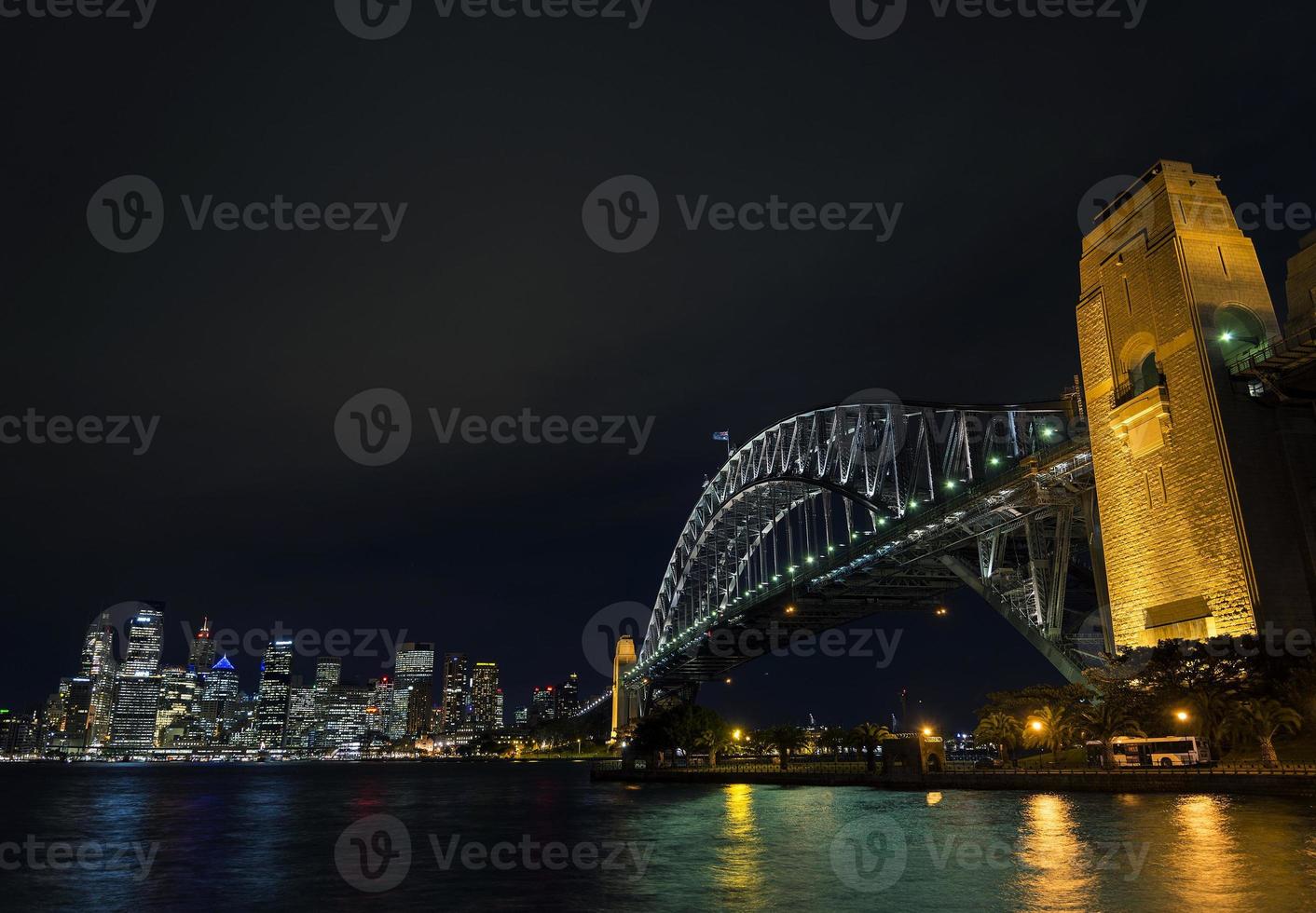 Famoso puente del puerto de Sydney y hitos del horizonte de la CDB en Australia por la noche foto