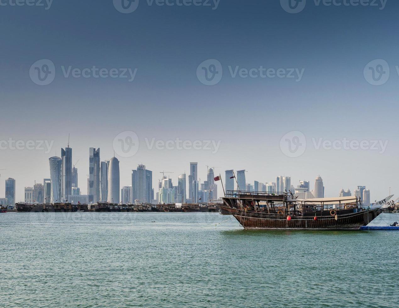 rascacielos de la ciudad de doha vista del horizonte urbano y barco dhow en qatar foto