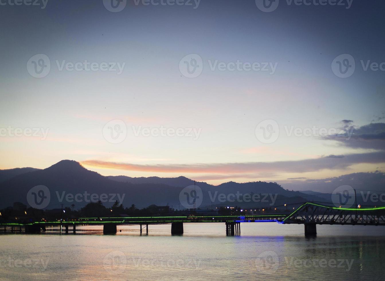 View of landmark old bridge in Kampot town Cambodia at sunset photo