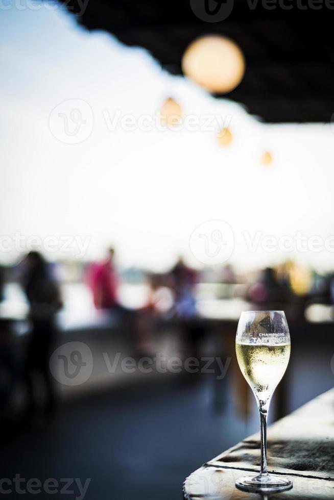 Copa de vino espumoso champán en el moderno bar al aire libre al atardecer foto