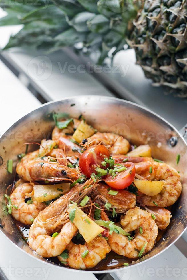 Stir fry prawns in spicy Asian food pineapple and herbs sauce photo