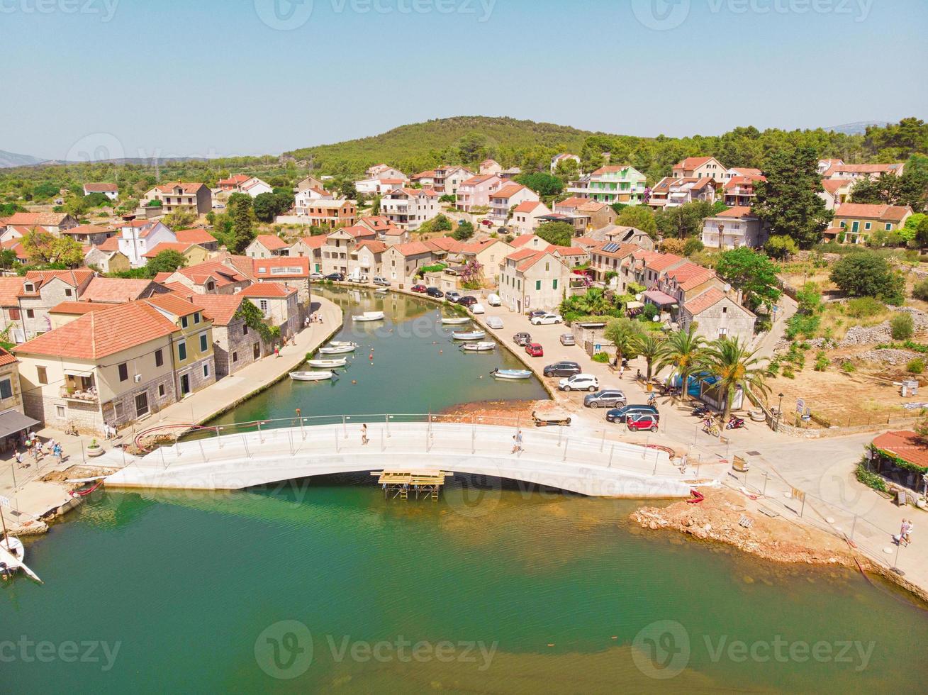 Bahía y ciudad vieja con iglesia en Vrboska en la isla de Hvar, Croacia foto