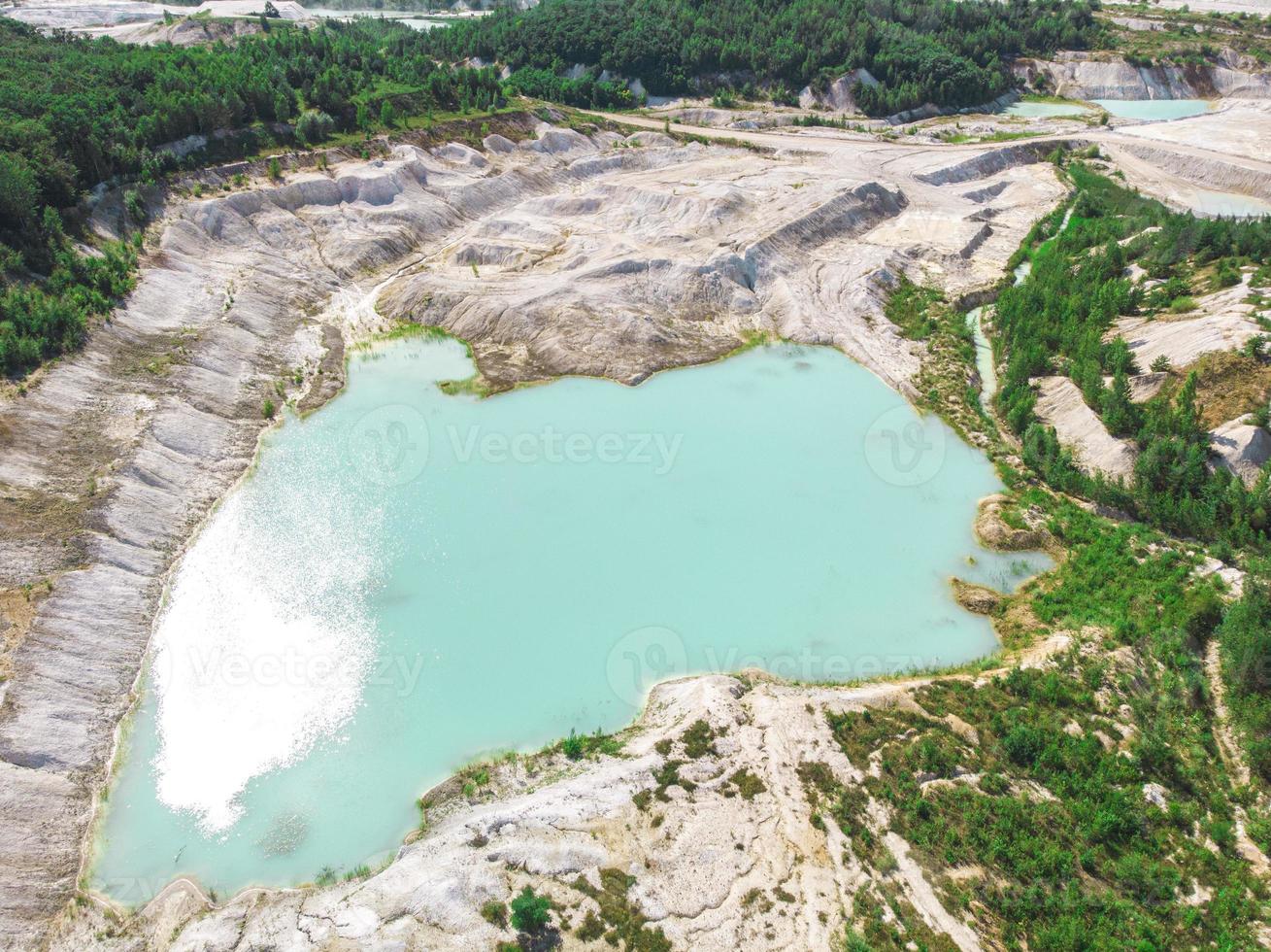 Drone view on a flooded kaolin quarry turquoise water and white shore photo