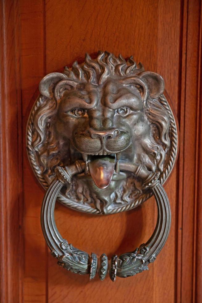 Antique door handle in the shape of a lion's face photo