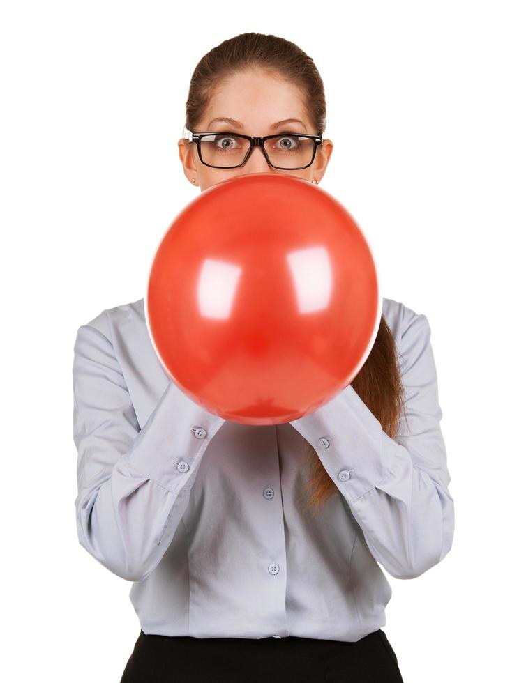 niña inflando un gran globo rojo foto