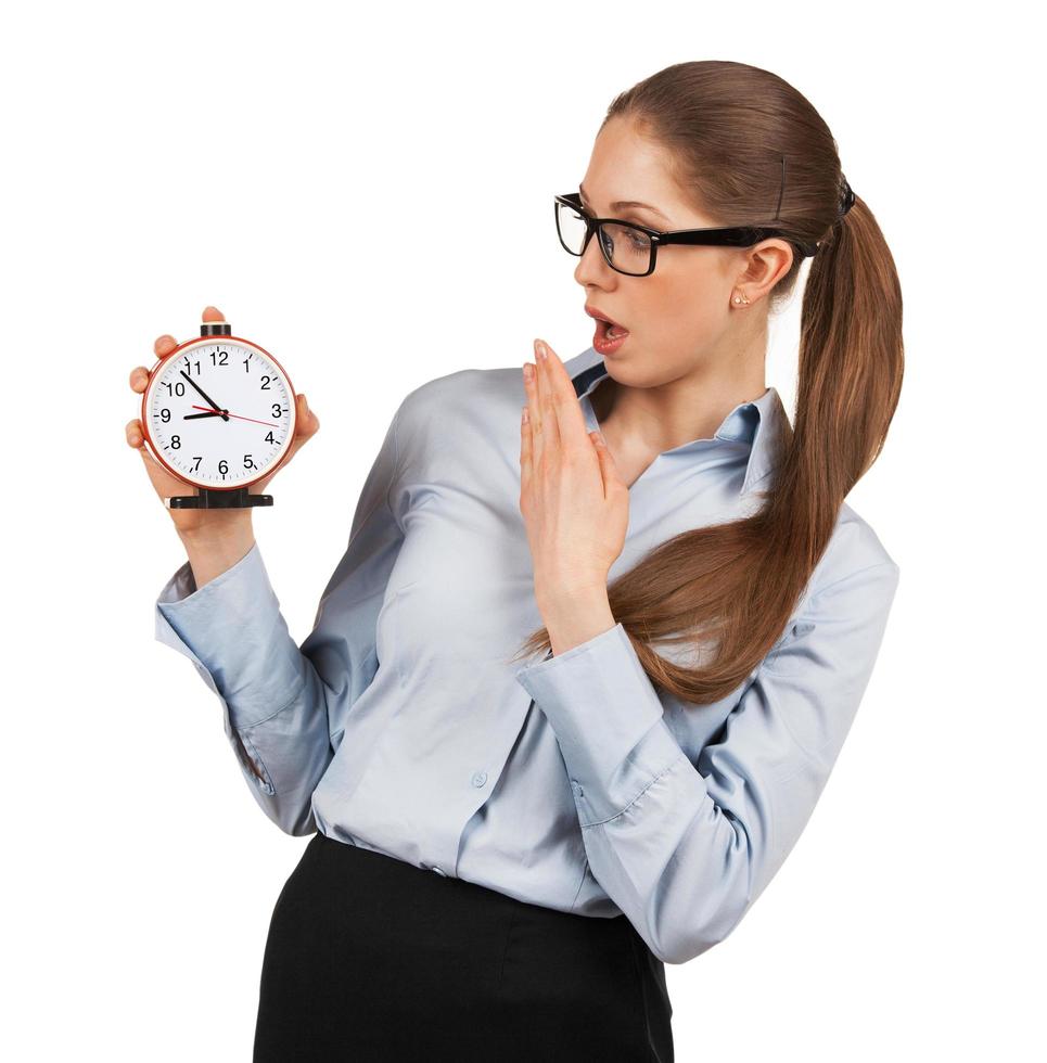 Surprised woman holding an alarm clock in a hand photo