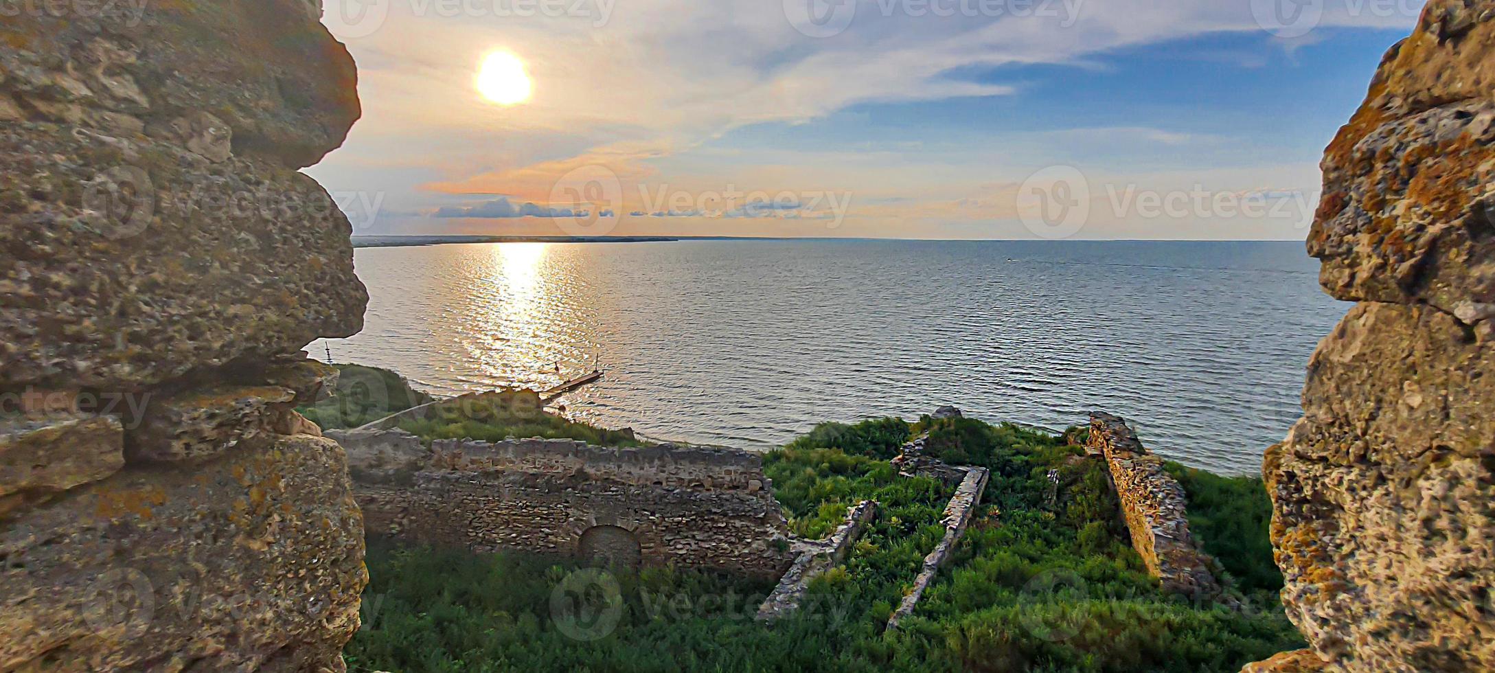 Ruined old fortress on the seashore. Blue sky. photo