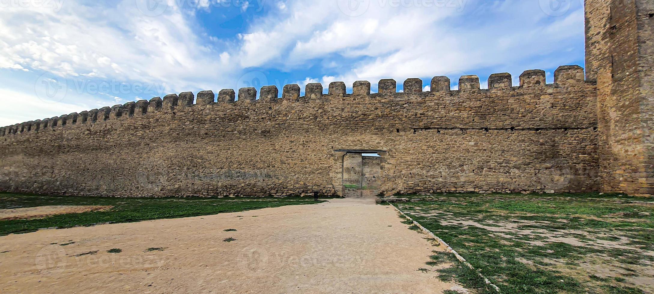 Ruined old fortress on the seashore. Blue sky. photo