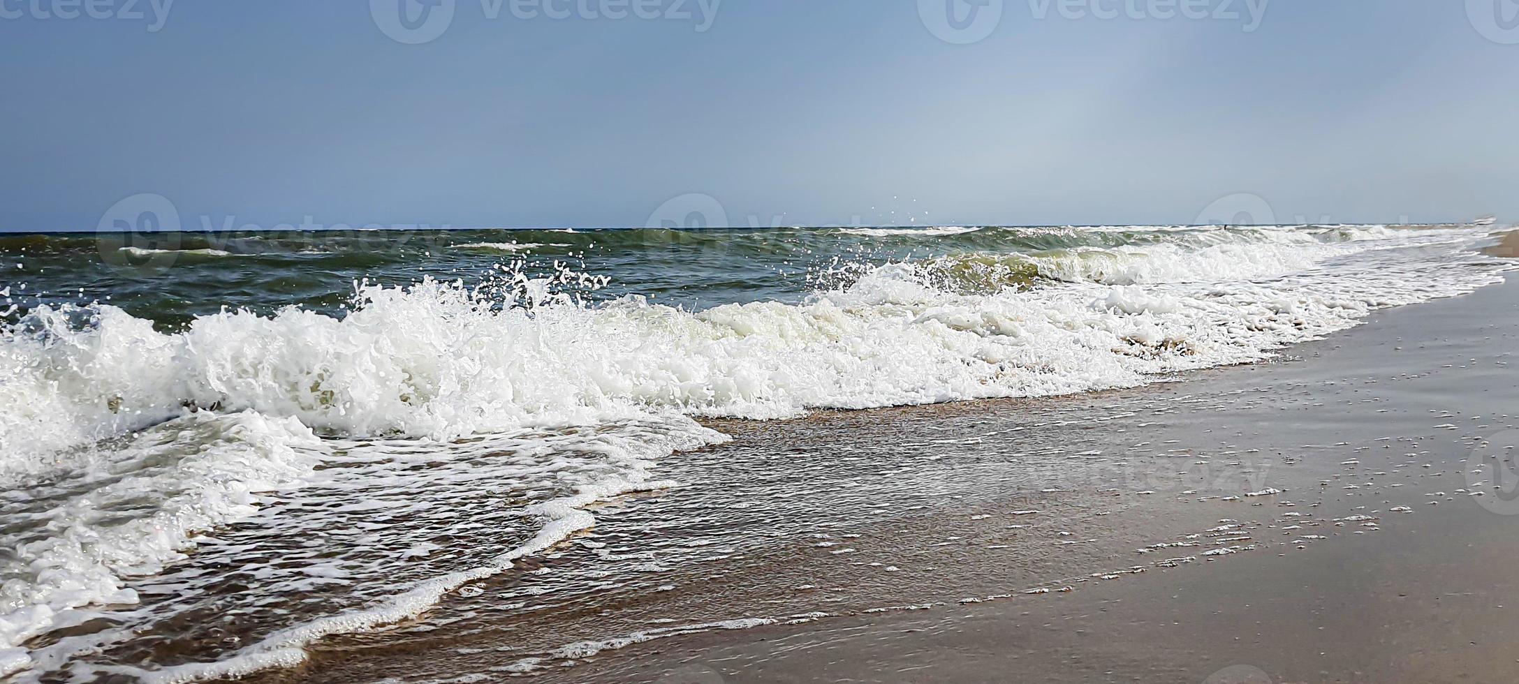 Seascape. Azure color of water, waves foaming on the shore. photo