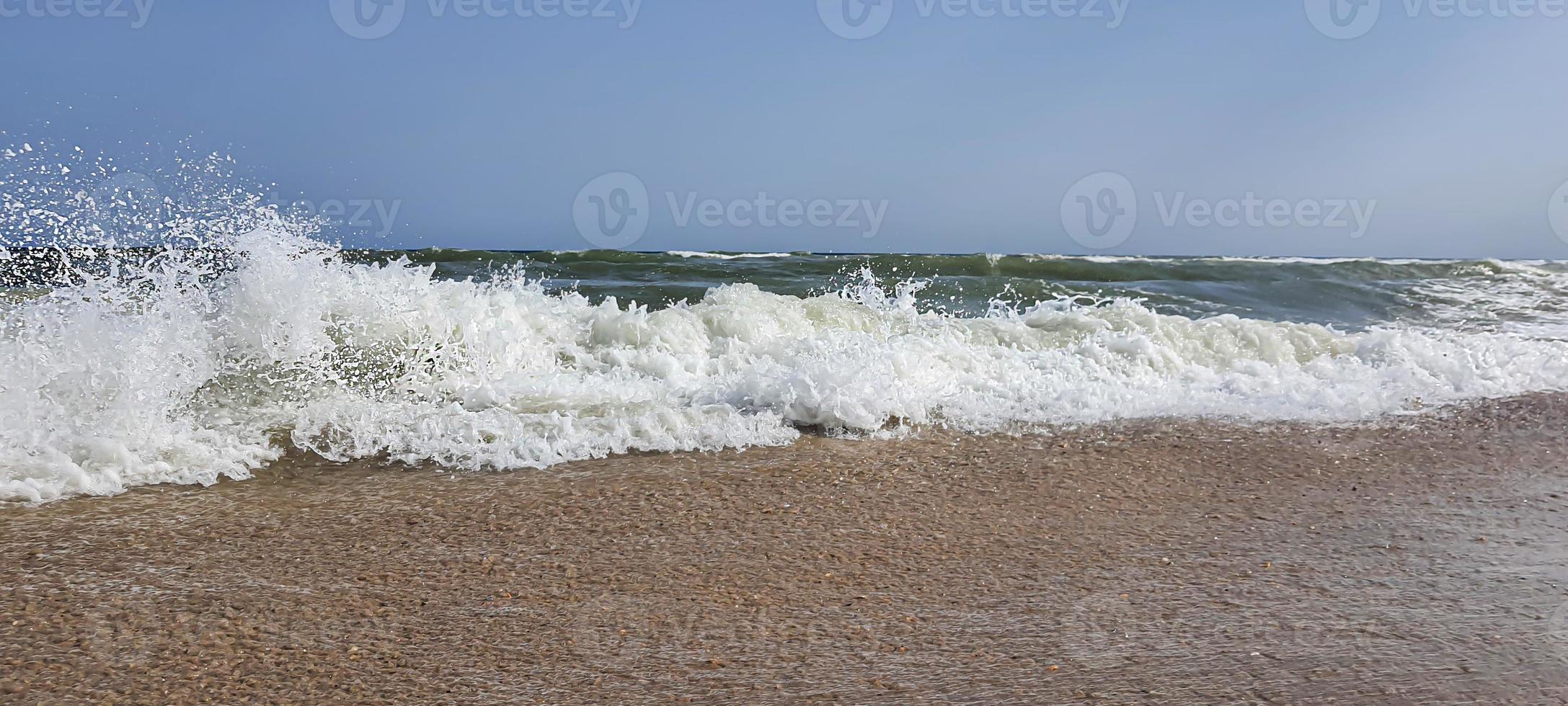 marina. color azul celeste del agua, olas espumosas en la orilla. foto