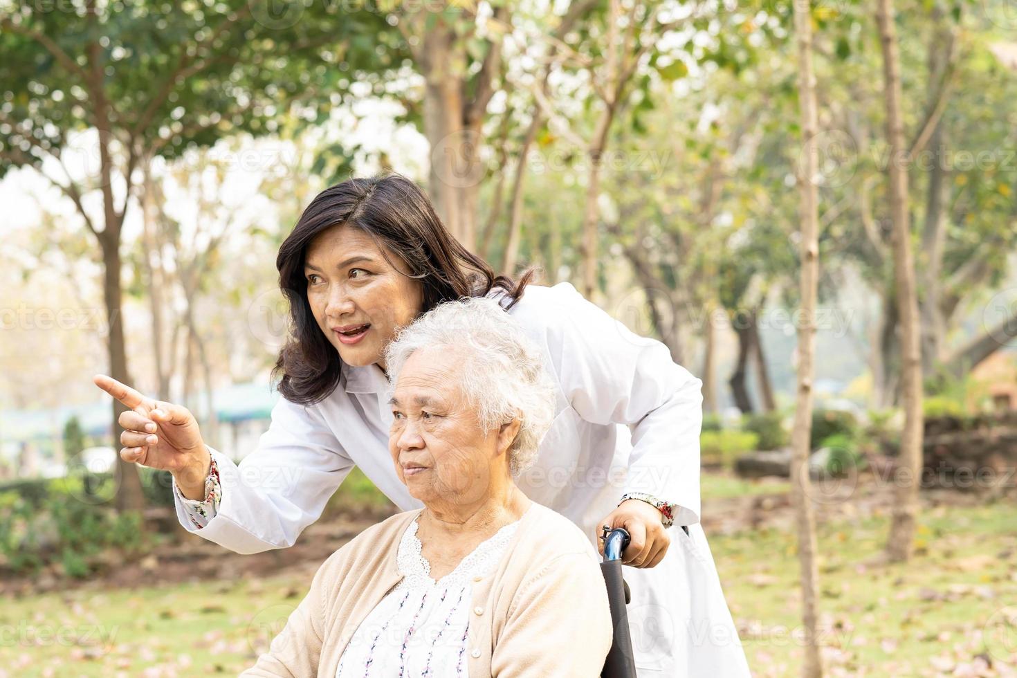 Doctor help Asian senior woman patient sitting on wheelchair photo
