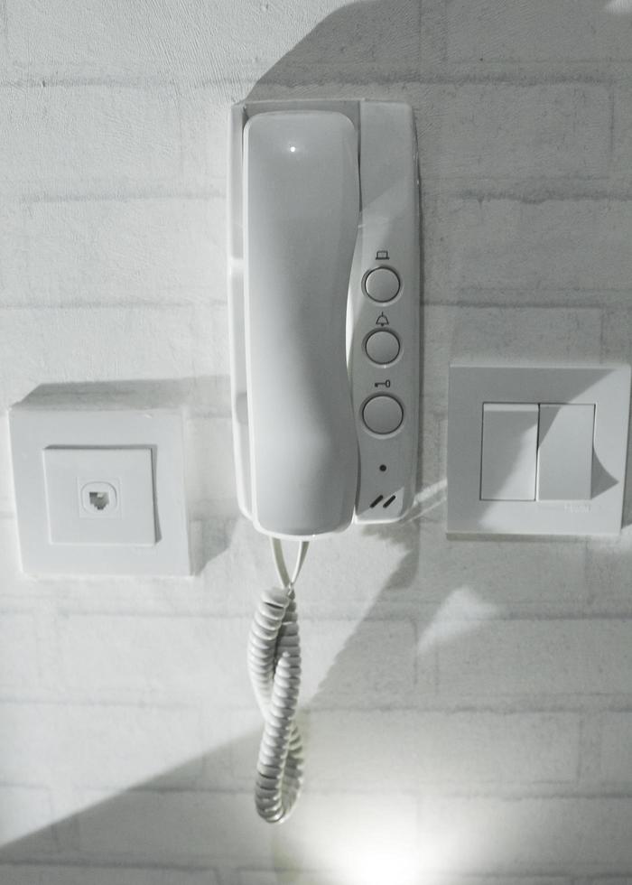 interior photo white telephone attached and hanging on the apartment