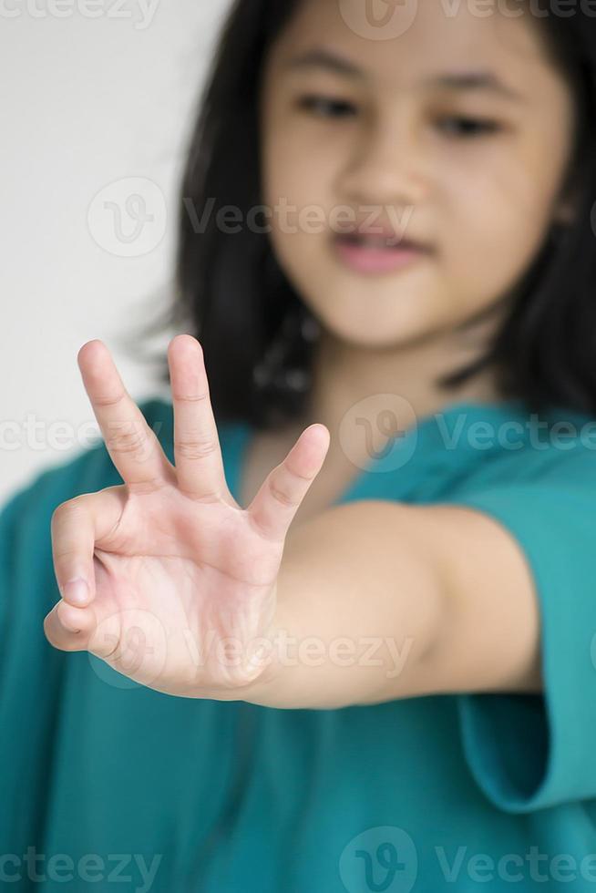 A young girl counting number with her fingers photo