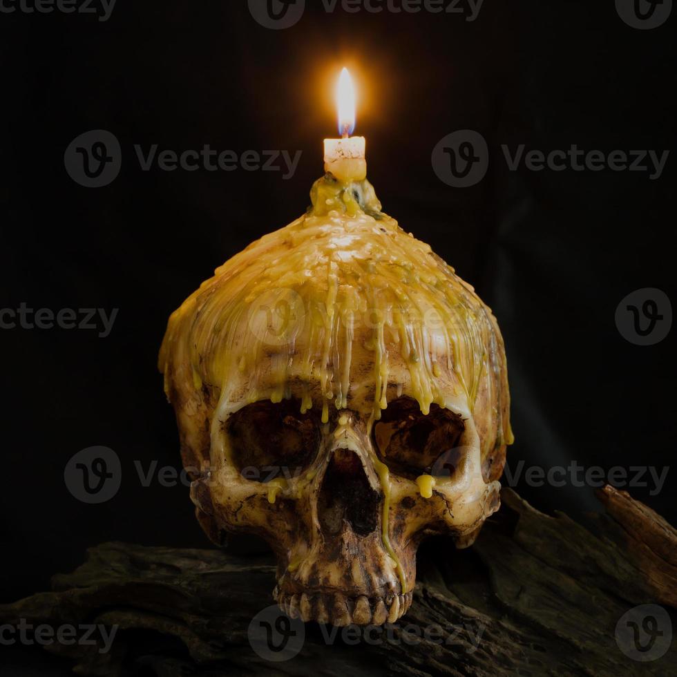 Cráneo con luz de velas en la parte superior con trazado de recorte en madera grunge foto