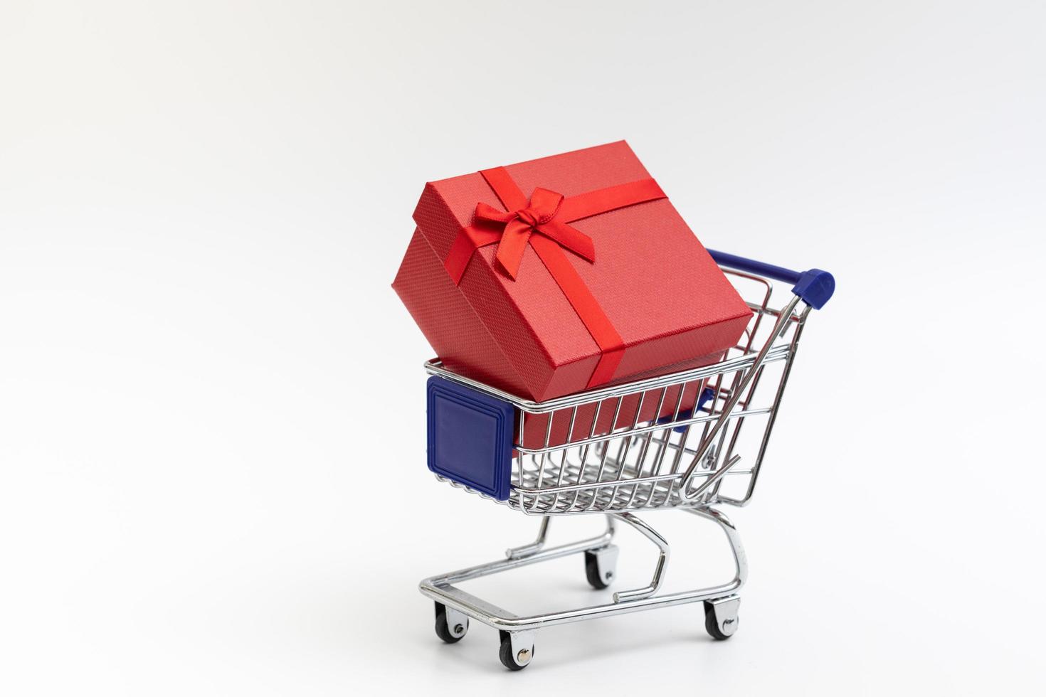 shopping cart present box with color ribbon on white background photo