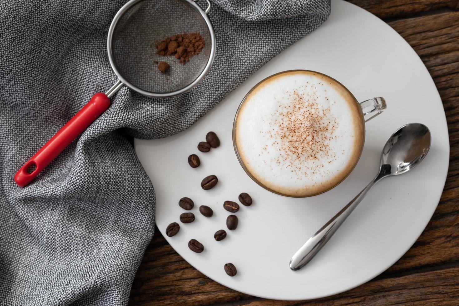 cappuccino coffee clear cup on wood background photo