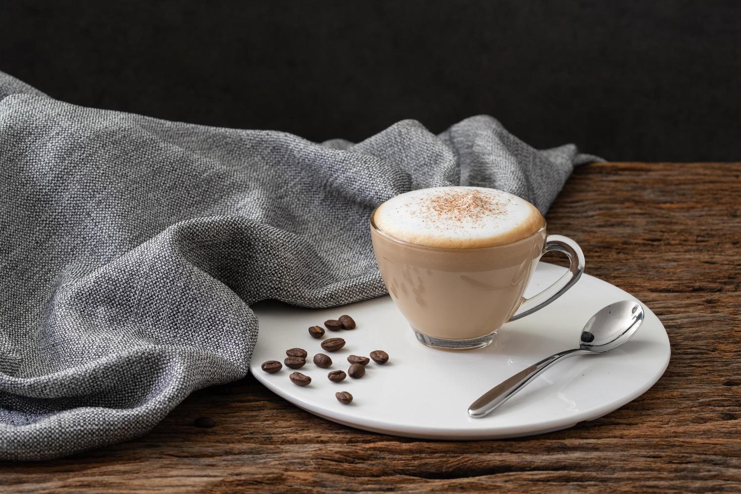 cappuccino coffee clear cup on wood background photo