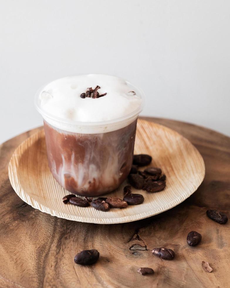 Bebida de chocolate helado con espuma y granos de cacao. foto