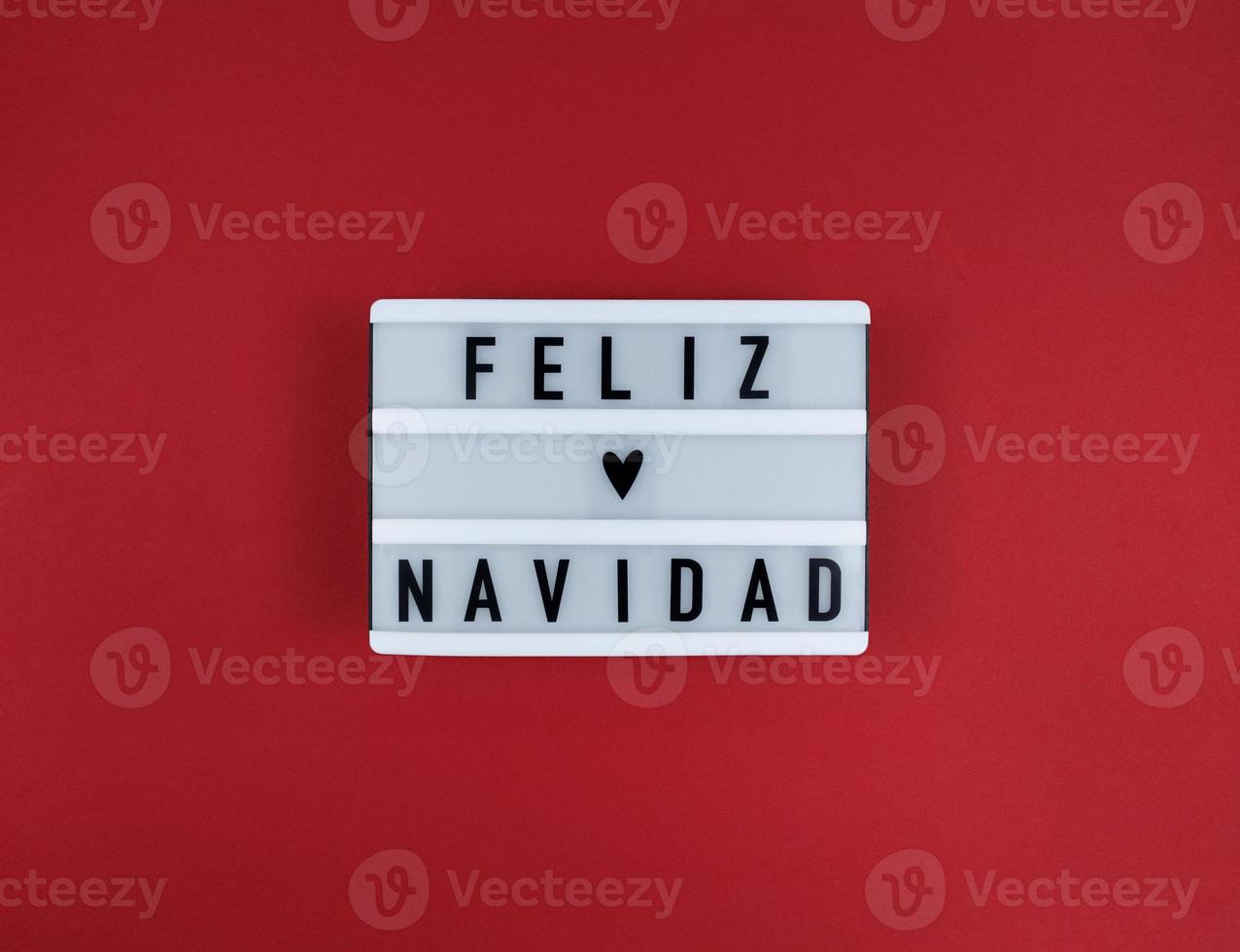 Light box with Feliz Navidad phrase, Spanish Merry Christmas on a red photo