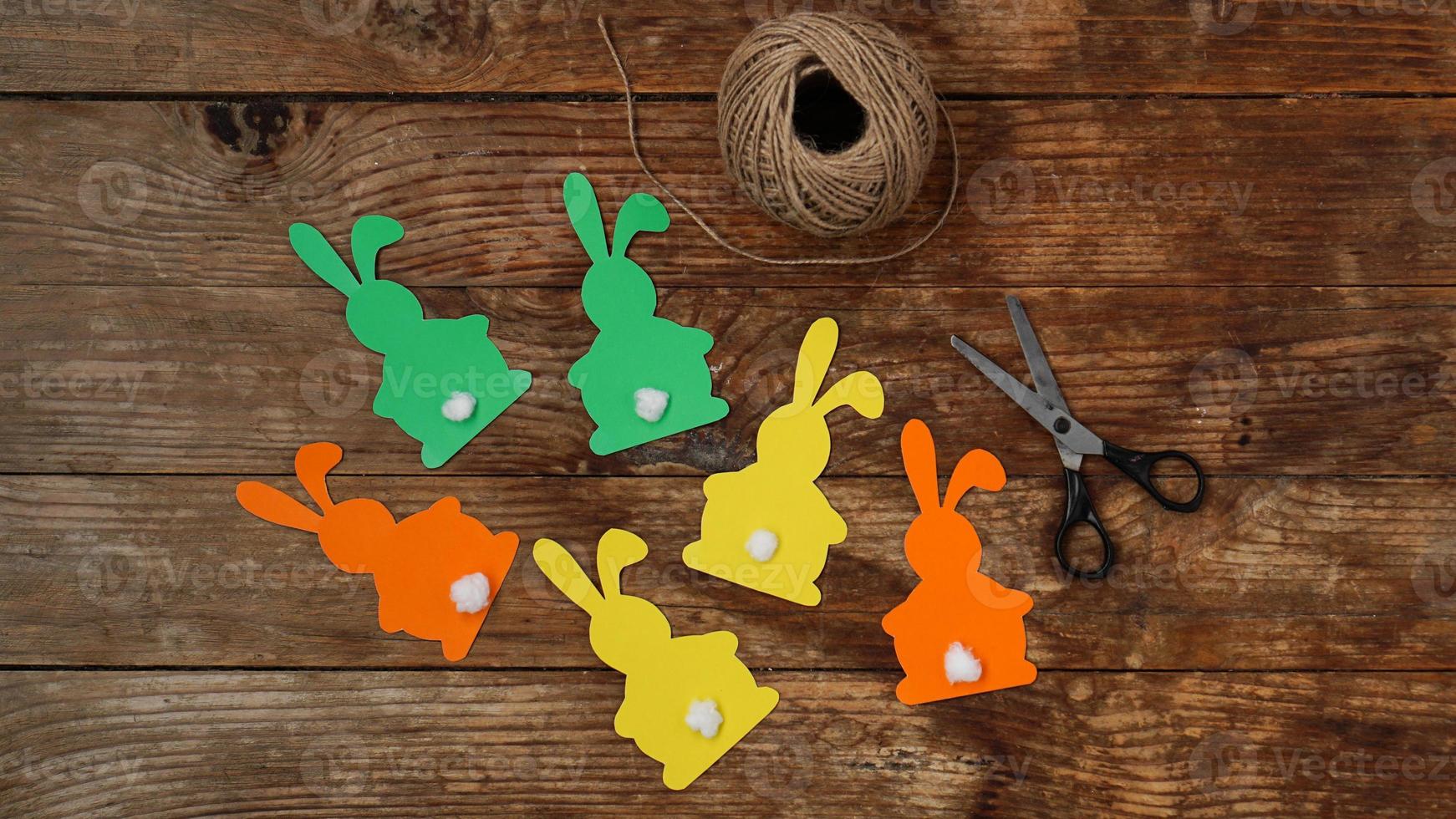 conejitos de pascua hechos de papel sobre una madera foto