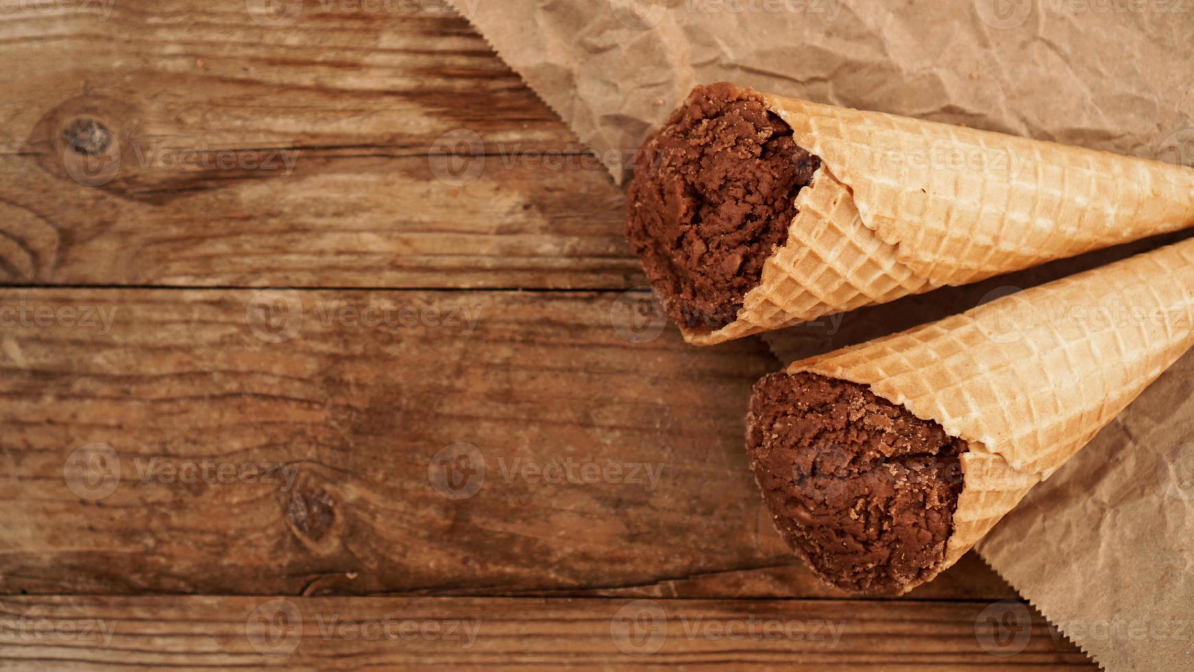 Chocolate ice cream in a waffle cone on craft paper photo